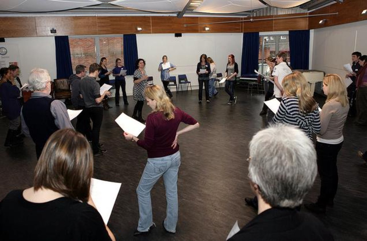 Youth Theatre Leaders in a workshop with paper in hand.